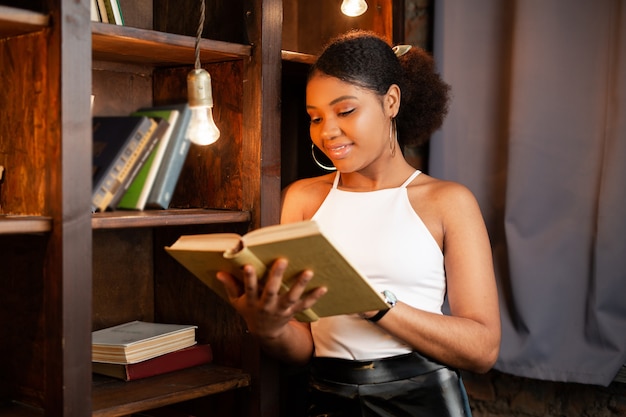 bella giovane donna africana leggendo un libro