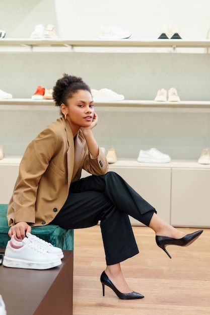 Bella giovane donna afroamericana durante lo shopping in un negozio di scarpe