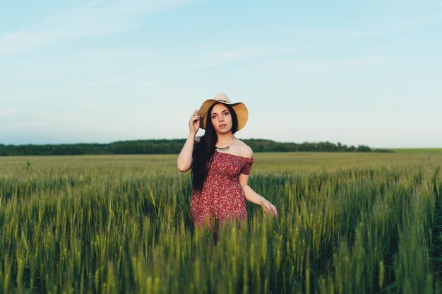 Bella giovane donna al tramonto nel campo