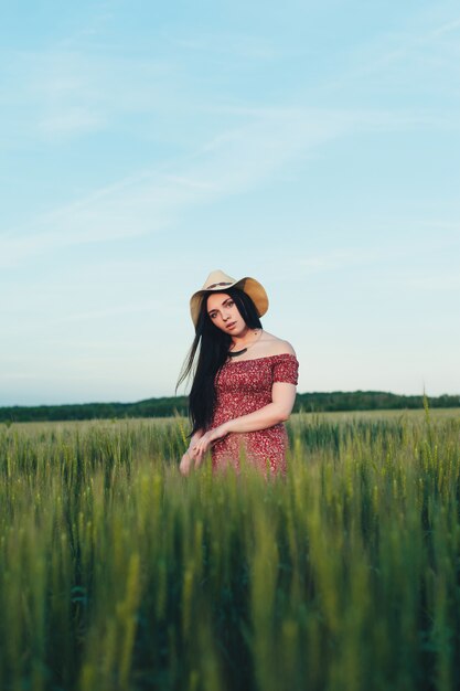 Bella giovane donna al tramonto nel campo