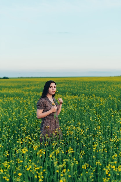 Bella giovane donna al tramonto nel campo