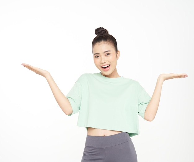 Bella giovane donna asiatica attraente con il gesto della mano e l'espressione del viso carino in abito sportivo isolato su sfondo bianco