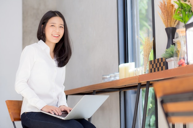 Bella giovane donna asiatica che lavora online sul computer portatile.