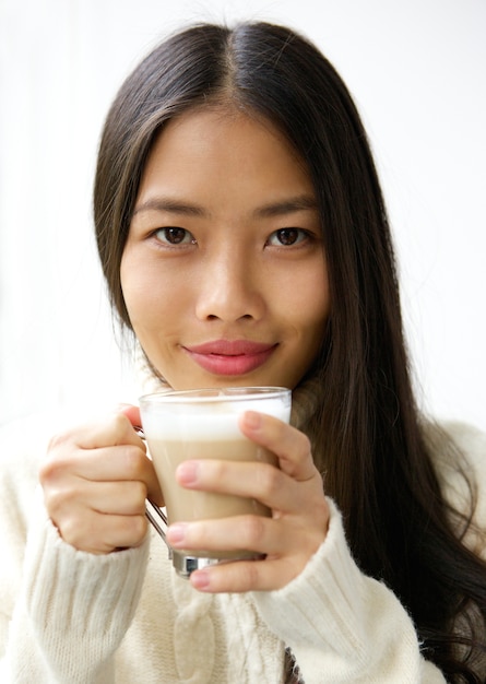 Bella giovane donna asiatica che sorride con la tazza di caffè