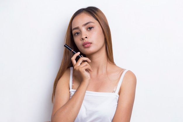 bella giovane donna asiatica che usa il rossetto isolato su sfondo bianco