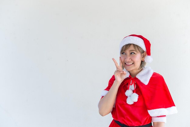 Bella giovane donna asiatica in abiti di Babbo Natale su sfondo biancoLa gente della Thailandia ha inviato la felicità per i bambiniBuon NataleBenvenuto all'invernoFelice concetto di donna