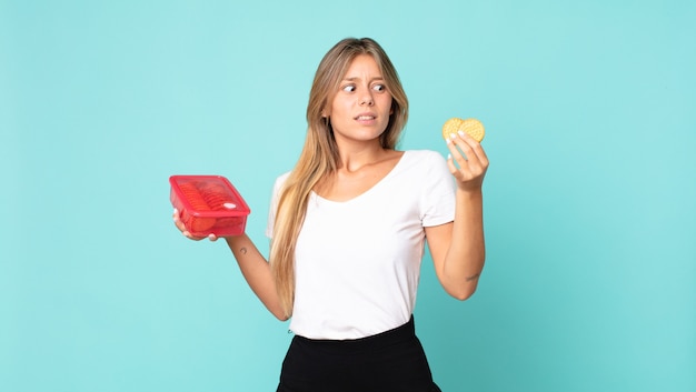 bella giovane donna bionda che tiene un tupperware