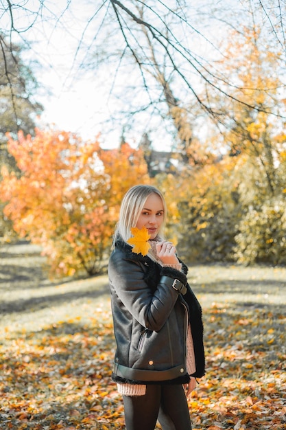 Bella giovane donna bionda in autunno parco Ritratto di un modello felice in abiti casual Autunno accogliente