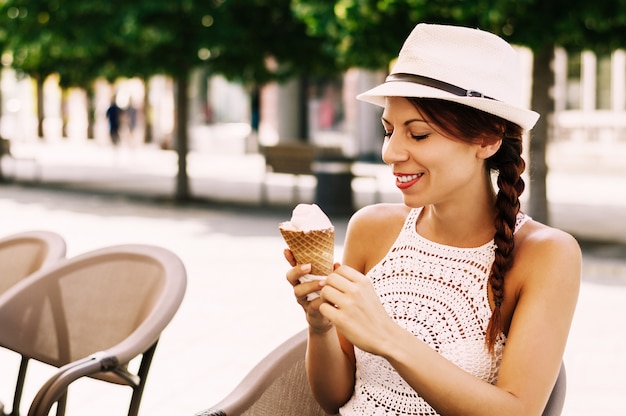 Bella giovane donna bruna avendo rinfrescante gelato.