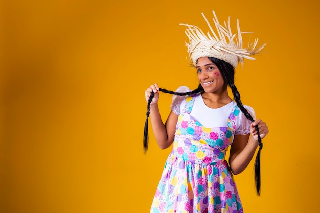 Bella giovane donna bruna in tipici abiti da festa brasiliani di giugno Bella donna vestita per la festa di giugno