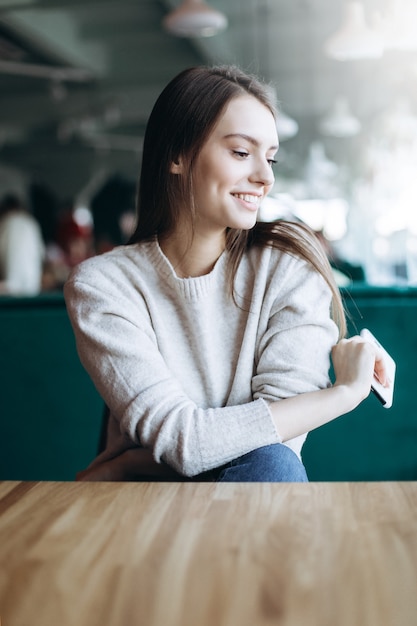 Bella giovane donna castana in un caffè