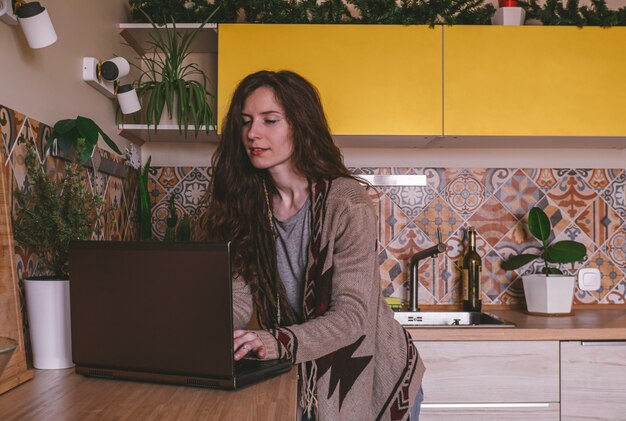 Bella giovane donna caucasica sicura che scrive su un computer portatile