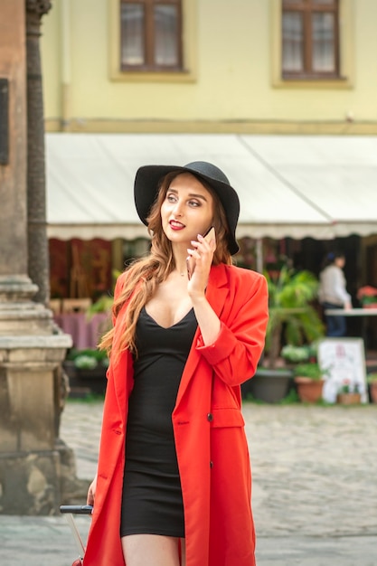 Bella giovane donna caucasica turistica che parla al telefono nella città vecchia