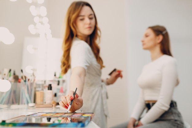 Bella giovane donna che applica la spazzola del viso di bellezza di trucco