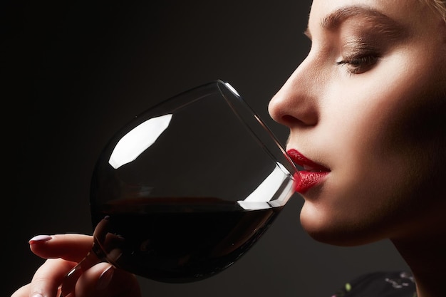 Bella giovane donna che beve vino