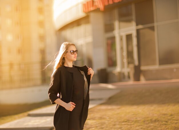 Bella giovane donna che cammina nella moda della città