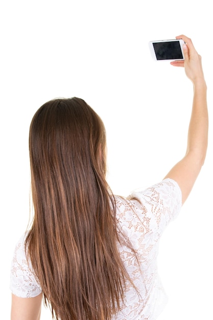 Bella giovane donna che cattura selfie su sfondo bianco