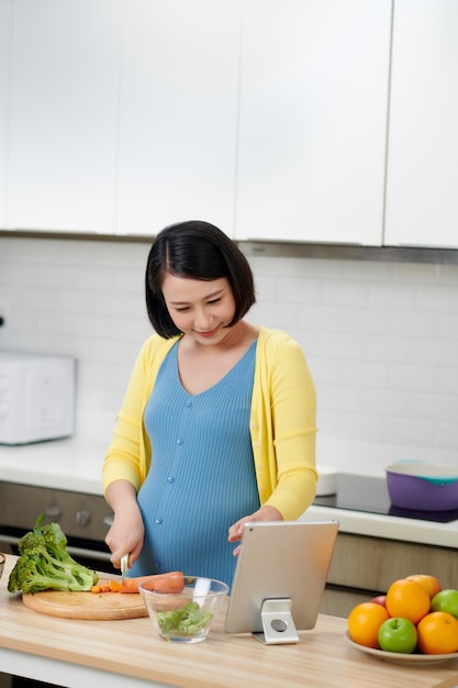 Bella giovane donna che cucina nella cucina