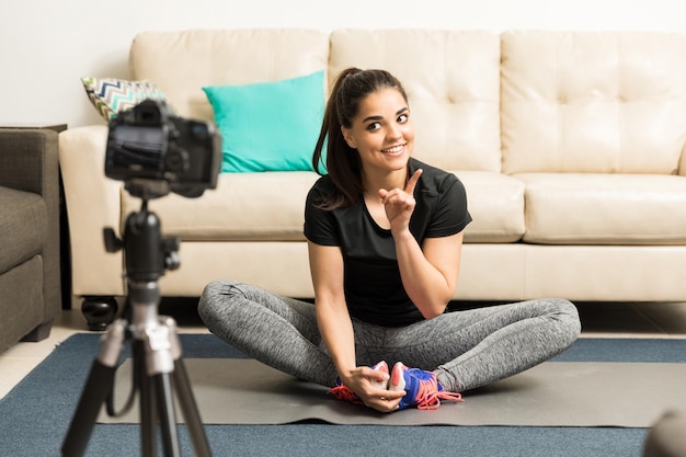 Bella giovane donna che dà consigli sul fitness mentre registra un video per il suo blog