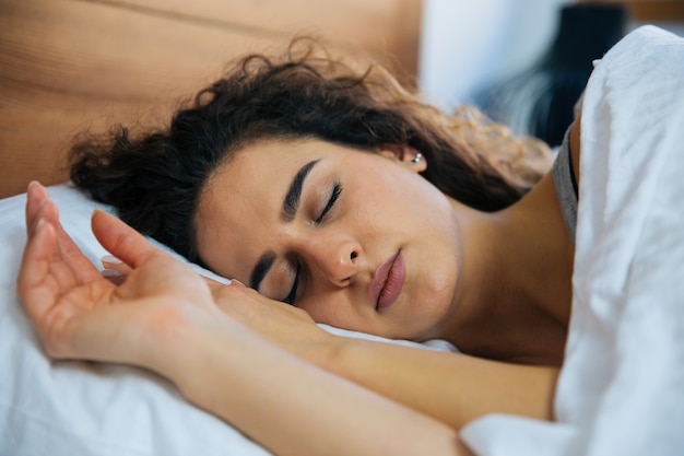 Bella giovane donna che dorme nel letto.