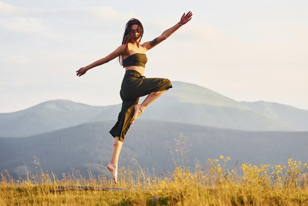 Bella giovane donna che fa esercizi di yoga Maestose montagne dei Carpazi Bellissimo paesaggio di natura incontaminata