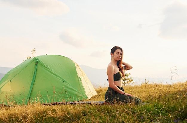 Bella giovane donna che fa esercizi di yoga Maestose montagne dei Carpazi Bellissimo paesaggio di natura incontaminata