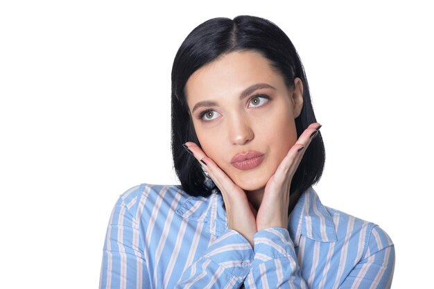 Bella giovane donna che fa espressione facciale in posa su sfondo bianco
