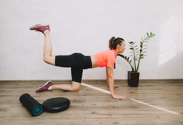 Bella giovane donna che fa fitness e yoga a casa