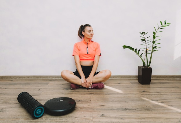 Bella giovane donna che fa fitness e yoga a casa