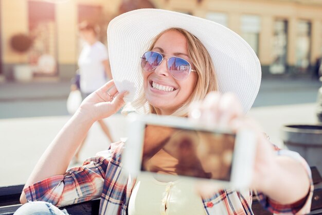 Bella giovane donna che fa la foto del selfie con lo smartphone.