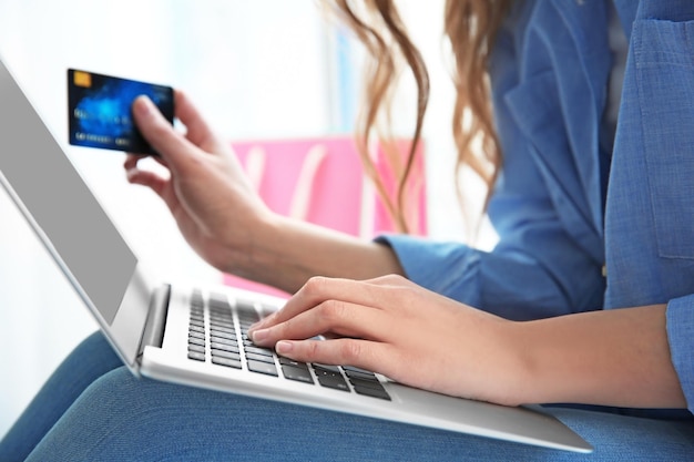 Bella giovane donna che fa shopping online a casa del primo piano