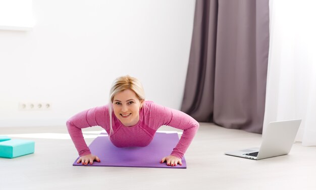 Bella giovane donna che fa yoga a casa.