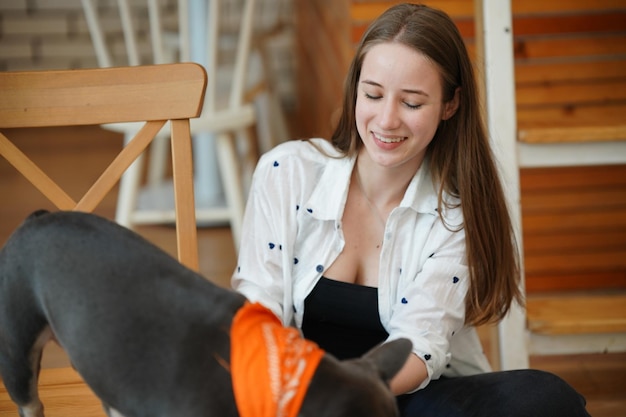 Bella giovane donna che gioca con il suo cane