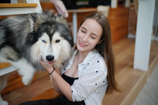 Bella giovane donna che gioca con il suo cane