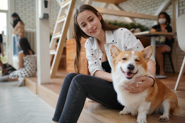 Bella giovane donna che gioca con il suo cane