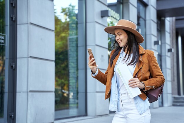 Bella giovane donna che guarda lo schermo dello smartphone