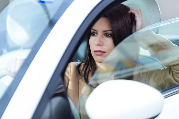 Bella giovane donna che guida la sua auto.