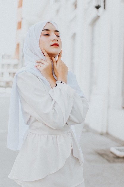 Bella giovane donna che indossa l'hijab mentre si trova contro un edificio