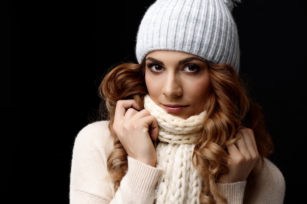 Bella giovane donna che indossa maglione e berretto di lana