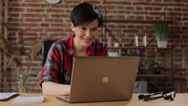 Bella giovane donna che lavora al computer portatile