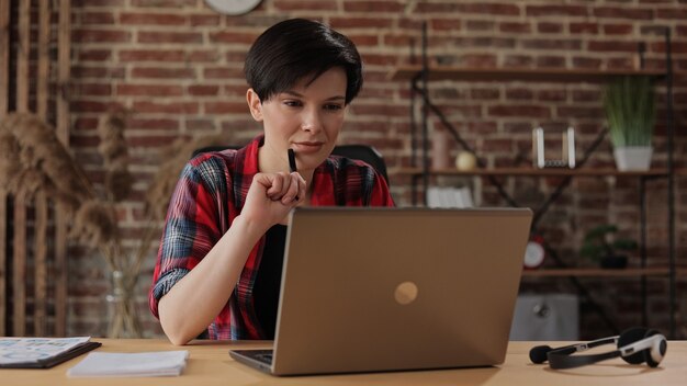 Bella giovane donna che lavora al computer portatile