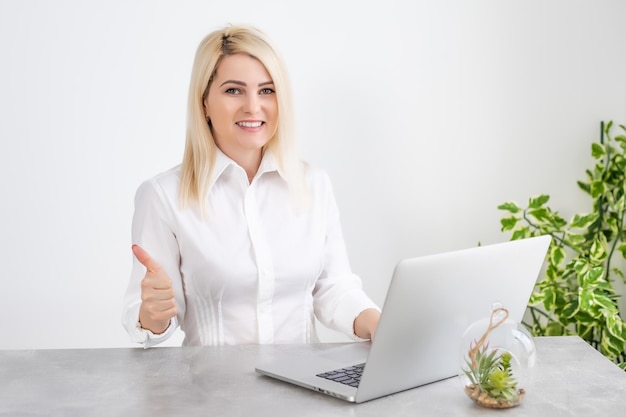 Bella giovane donna che lavora al suo computer portatile nel suo ufficio.