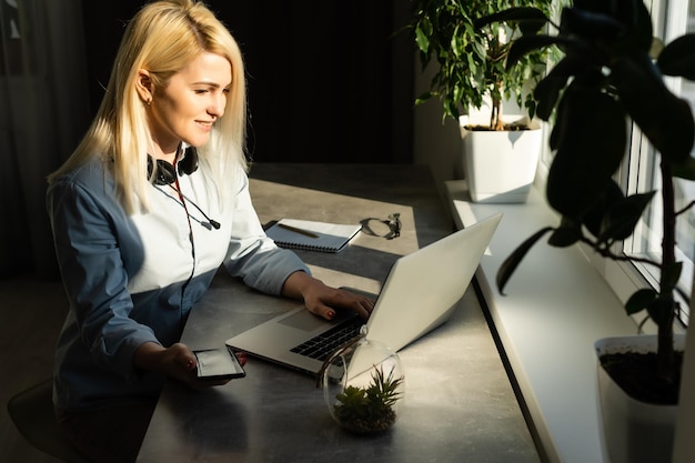 Bella giovane donna che lavora al suo computer portatile nel suo ufficio.