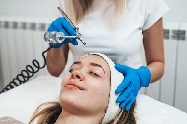 Bella giovane donna che ottiene un trattamento di mesoterapia al salone di bellezza cosmetica.