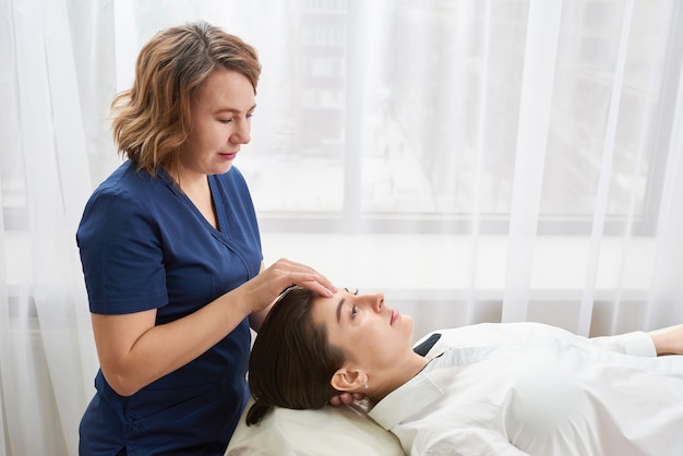 Bella giovane donna che ottiene un trattamento viso e testa al salone di bellezza