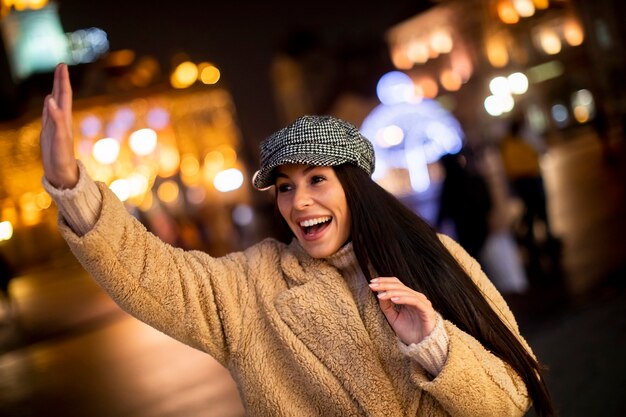 Bella giovane donna che saluta per strada a Natale