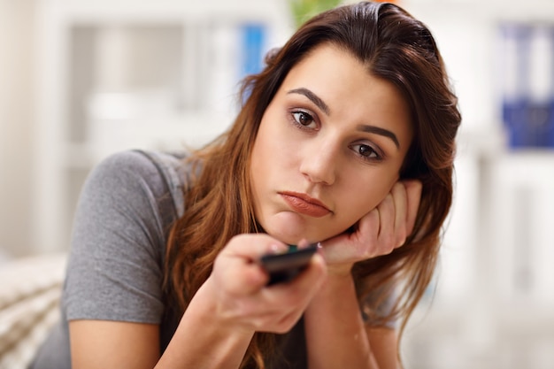 bella giovane donna che si rilassa a casa guardando la tv