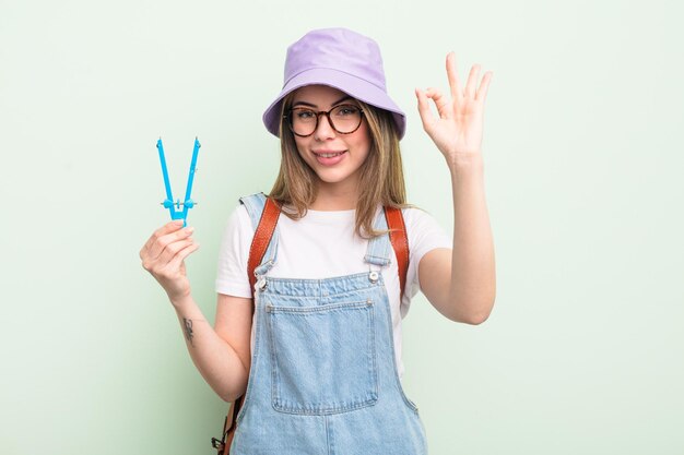 bella giovane donna che si sente felice, mostrando approvazione con un gesto ok. concetto di studente