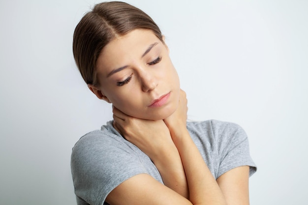 Bella giovane donna che soffre di dolore al collo.