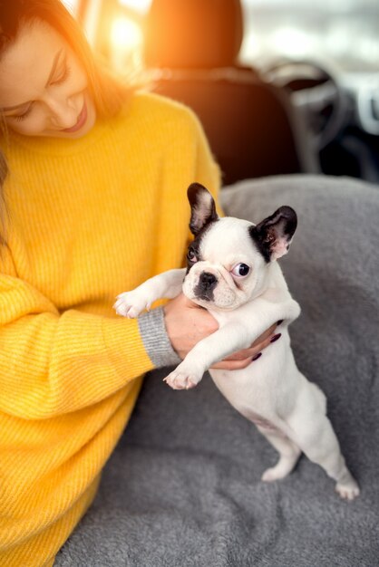 Bella giovane donna che tiene adorabile cagnolino tra le braccia.